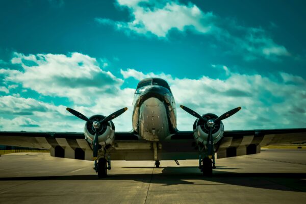 Front view of a classic military aircraft on a runway under a clear blue sky.